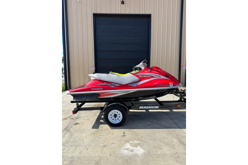 Slide: The Image of 2006 Yamaha WaveRunner VX110 Deluxe in red on a trailer, parked outside a building. - 2