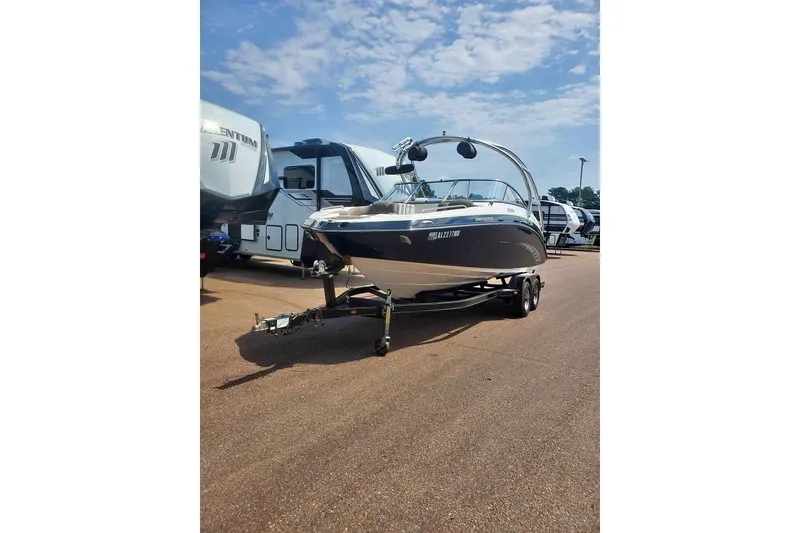 The Image of 2011 Yamaha Boats 242 Limited S on trailer, parked outdoors under a clear sky. - 2