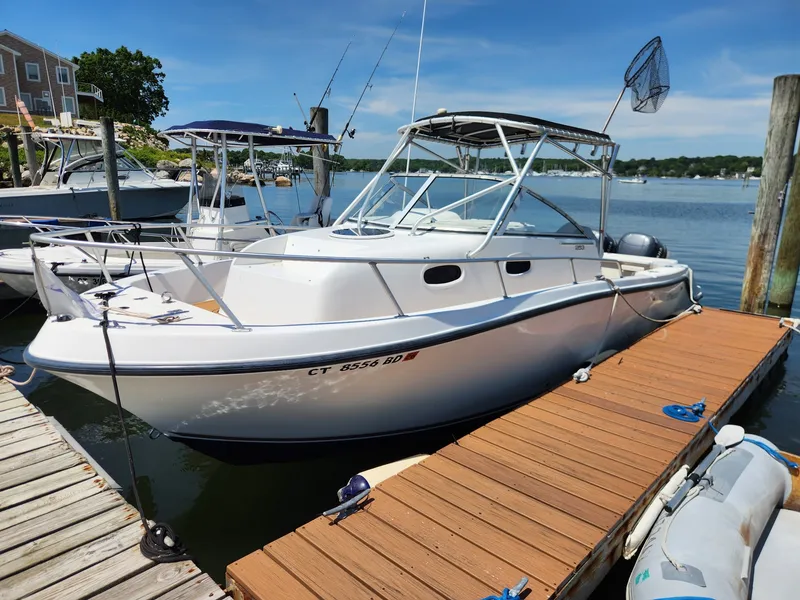 The Image of 2001 Mako 253 Walk Around docked at a wooden pier, with clear skies in the background. - 0