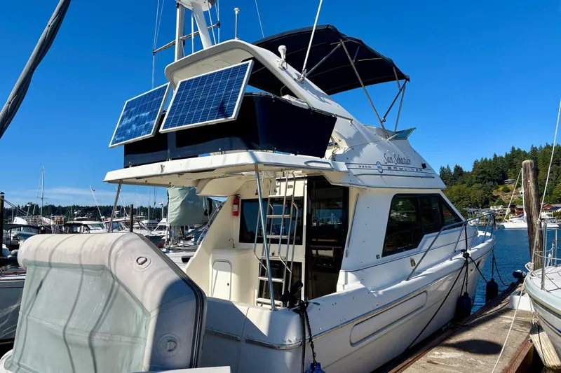 Slide: The Image of 1998 Bayliner 3388 Command Bridge Motoryacht with solar panels docked at marina. - 3