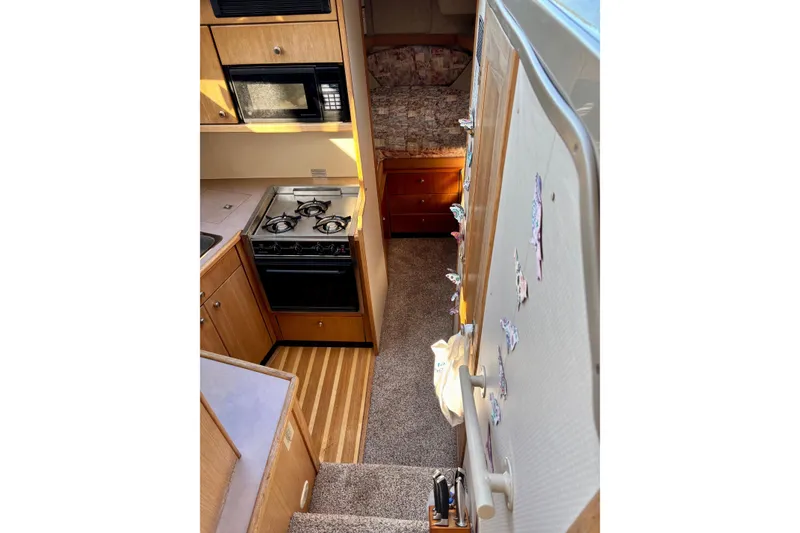 Slide: The Image of Interior of 1998 Bayliner 3388 Command Bridge Motoryacht with kitchen and cozy sleeping area. - 24