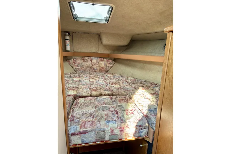 Slide: The Image of 1998 Bayliner 3388 Command Bridge Motoryacht cabin with patterned bedding and overhead hatch. - 28