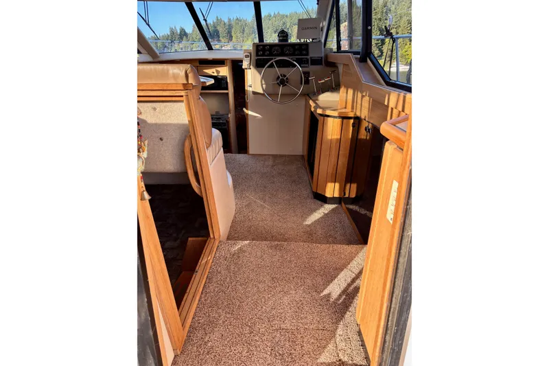 Slide: The Image of 1998 Bayliner 3388 Command Bridge Motoryacht interior with helm, wood accents, and carpeted flooring. - 17