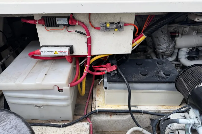 Slide: The Image of Engine compartment of a 1998 Bayliner 3388 Command Bridge Motoryacht, featuring batteries and wiring. - 38