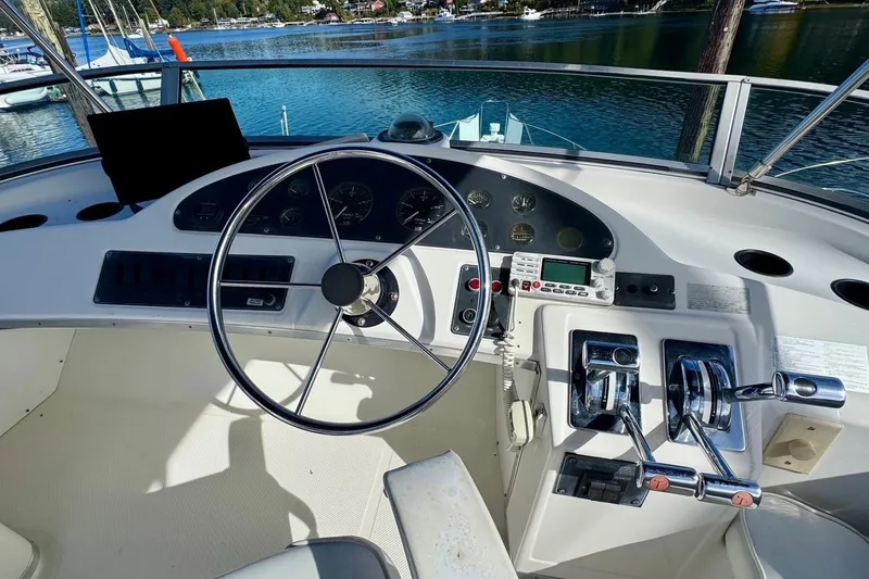 Slide: The Image of 1998 Bayliner 3388 Command Bridge Motoryacht helm with steering wheel and controls. - 13