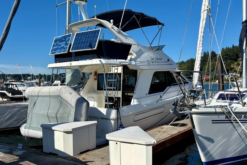 Slide: The Image of 1998 Bayliner 3388 Command Bridge Motoryacht docked with solar panels, sunny marina setting. - 46