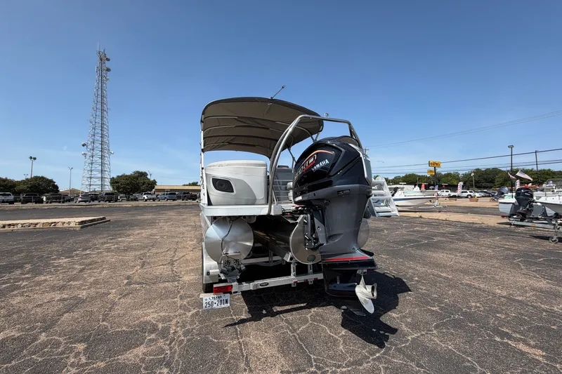 Slide: The Image of 2025 Bennington 22 L Quad Bench pontoon boat with Yamaha outboard motor in a parking lot. - 9