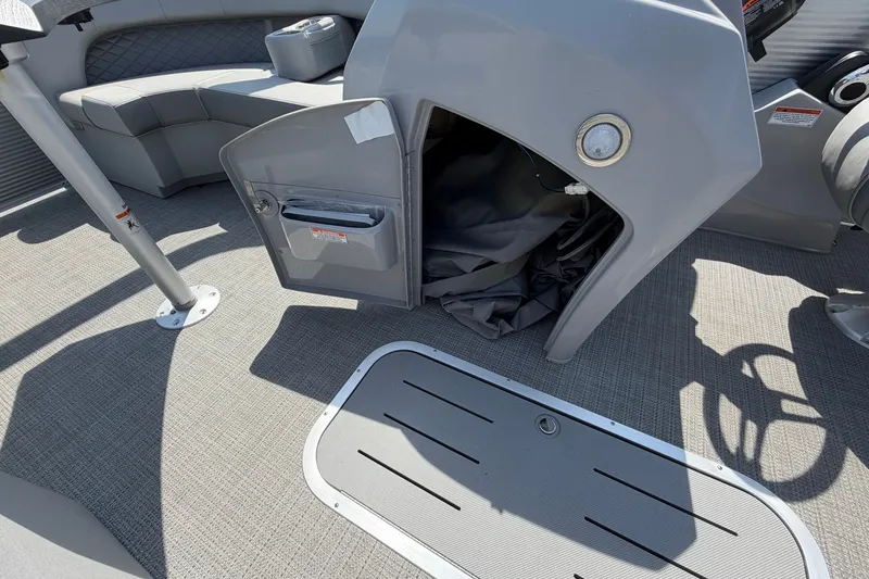 Slide: The Image of 2025 Bennington 22 L Quad Bench interior with open storage compartment and seating. - 44