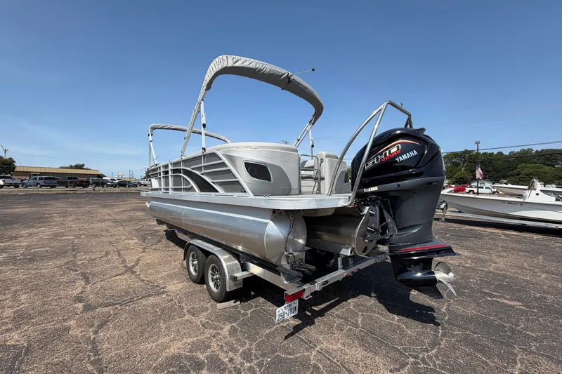 Slide: The Image of 2025 Bennington 22 L Quad Bench pontoon boat with Yamaha engine on trailer. - 2