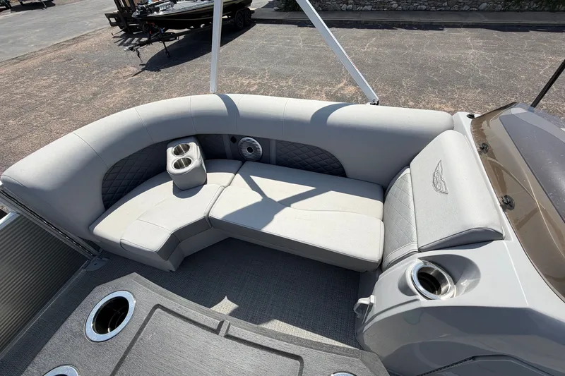 Slide: The Image of 2025 Bennington 22 L Quad Bench boat interior with gray seating and cup holders. - 19