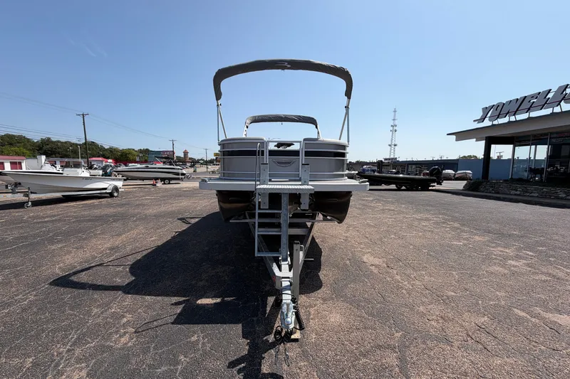 Slide: The Image of 2025 Bennington 22 L Quad Bench pontoon boat on trailer in dealership lot. - 6