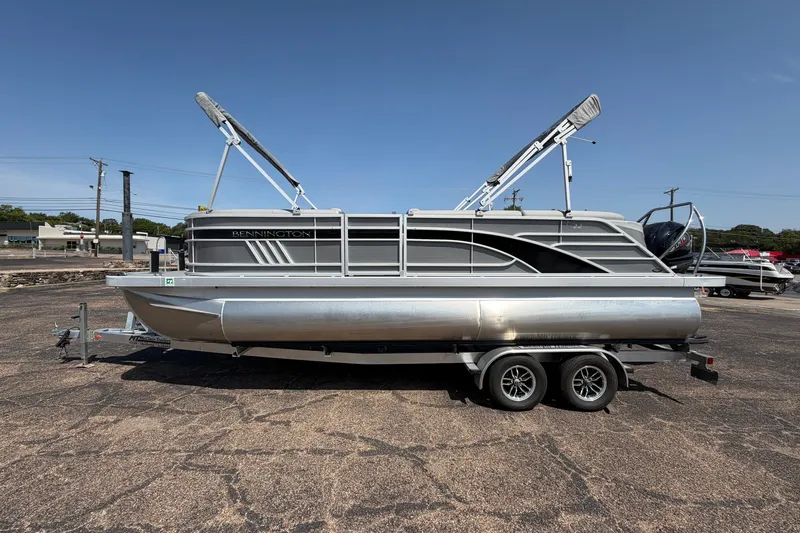 The Image of 2025 Bennington 22 L Quad Bench pontoon boat on trailer, parked outdoors. - 0