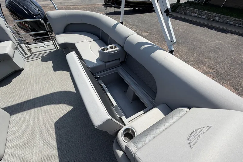 Slide: The Image of 2025 Bennington 22 L Quad Bench boat interior with open storage compartment and cup holders. - 27
