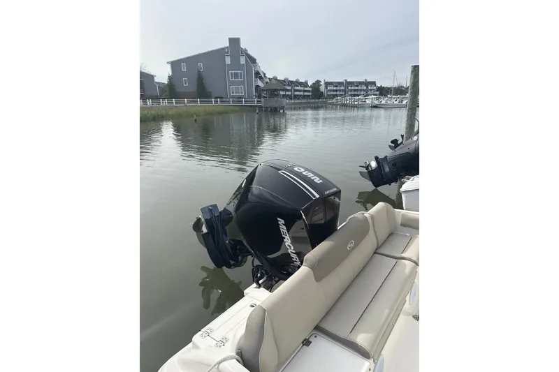 Slide: The Image of 2024 Key West 239 FS boat with Mercury outboard engine docked in a serene marina. - 6
