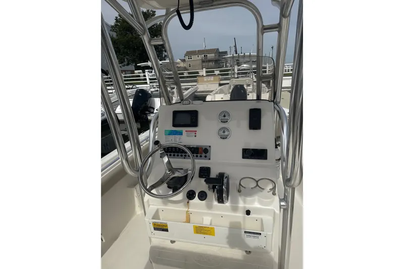 Slide: The Image of 2024 Key West 239 FS boat console with steering wheel, gauges, and controls. - 2