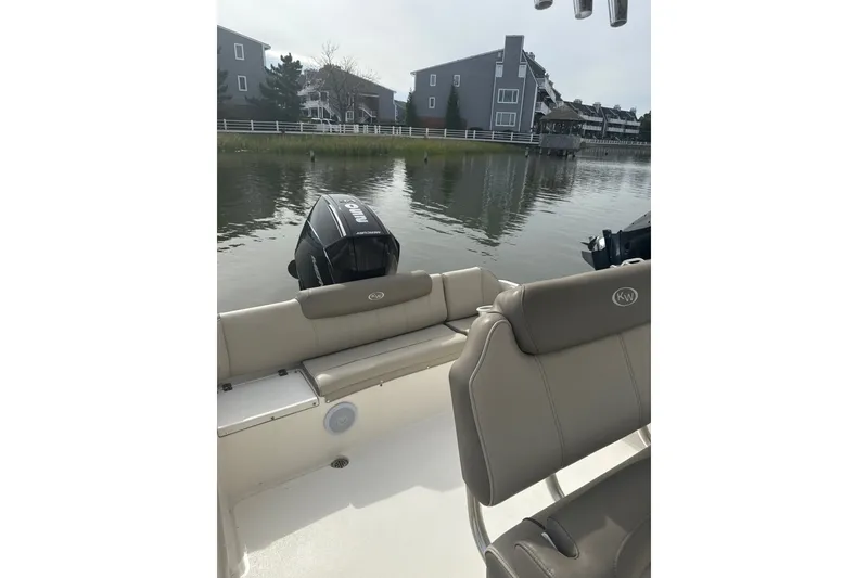Slide: The Image of 2024 Key West 239 FS boat interior with seating and outboard motor on calm water. - 5
