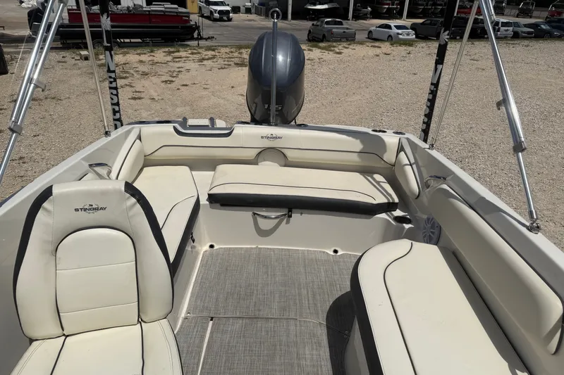 Slide: The Image of 2020 Stingray 182 SC boat interior with cushioned seating and motor view. - 12