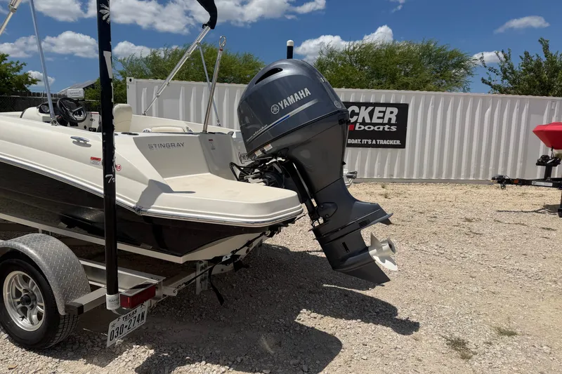 Slide: The Image of 2020 Stingray 182 SC boat with Yamaha outboard motor on a trailer, parked outdoors. - 2
