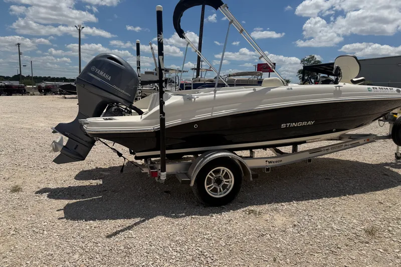 Slide: The Image of 2020 Stingray 182 SC boat on trailer with Yamaha outboard motor, parked outdoors. - 4
