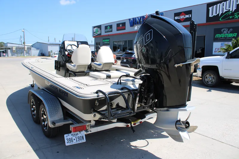 Slide: The Image of 2013 Blazer 675 Ultimate Bay boat with powerful outboard motor, parked at a dealership. - 19