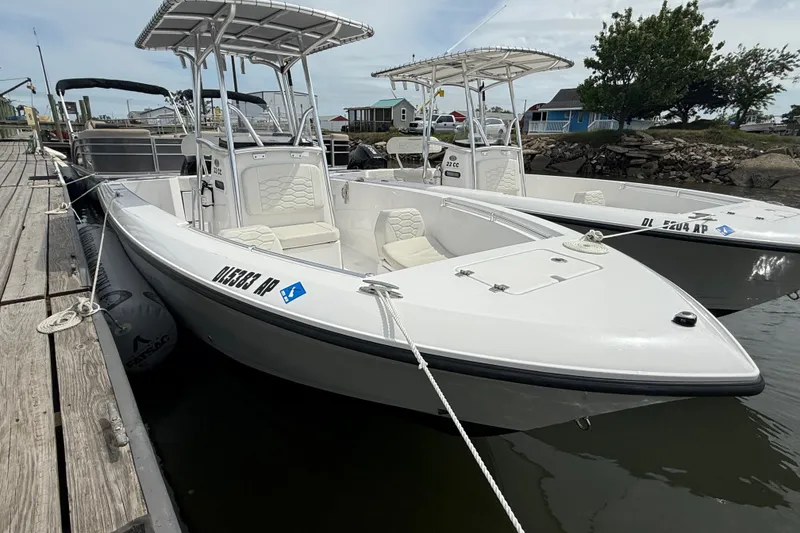 The Image of 2024 Aquasport 2200 Center Console boat docked, showcasing sleek design and spacious seating. - 1