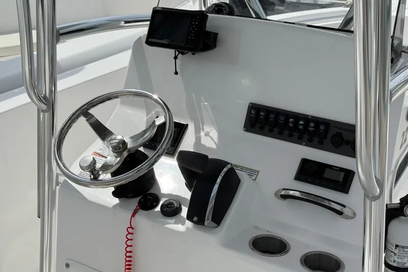 Slide: The Image of 2024 Aquasport 2200 Center Console helm with steering wheel and control panel. - 8