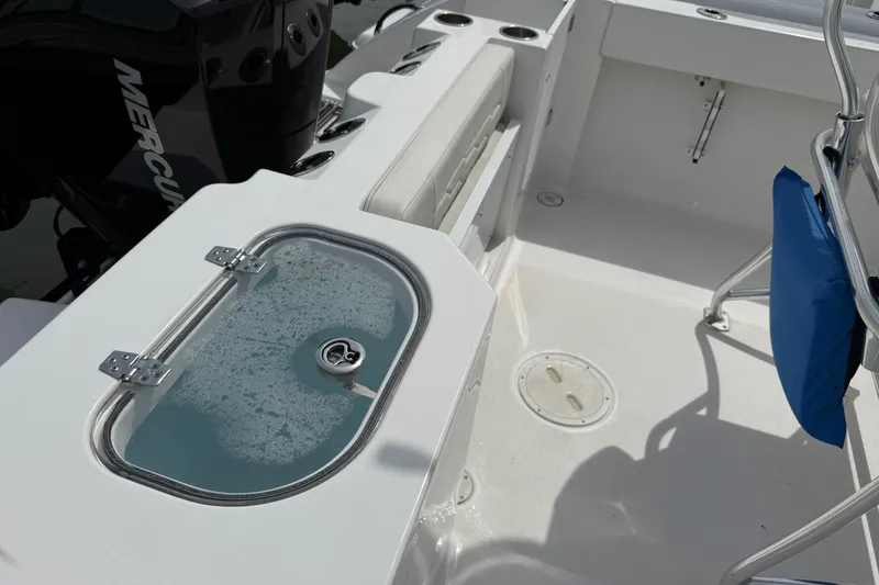 Slide: The Image of 2024 Aquasport 2200 Center Console boat interior with livewell and Mercury engine. - 9