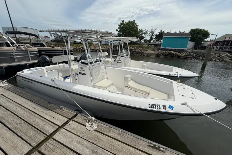 Slide: The Image of 2024 Aquasport 2200 Center Console boat docked at a marina, showcasing sleek design. - 3