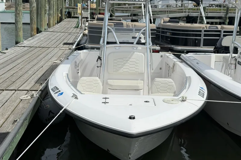 Slide: The Image of 2024 Aquasport 2200 Center Console boat docked at marina. - 2