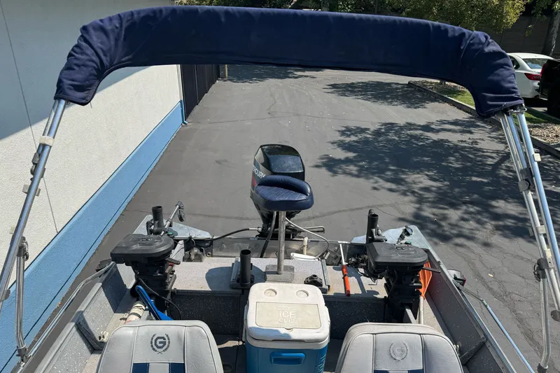 Slide: The Image of 1995 Gregor Eagle 16 boat with motor and seating, parked on pavement. - 15