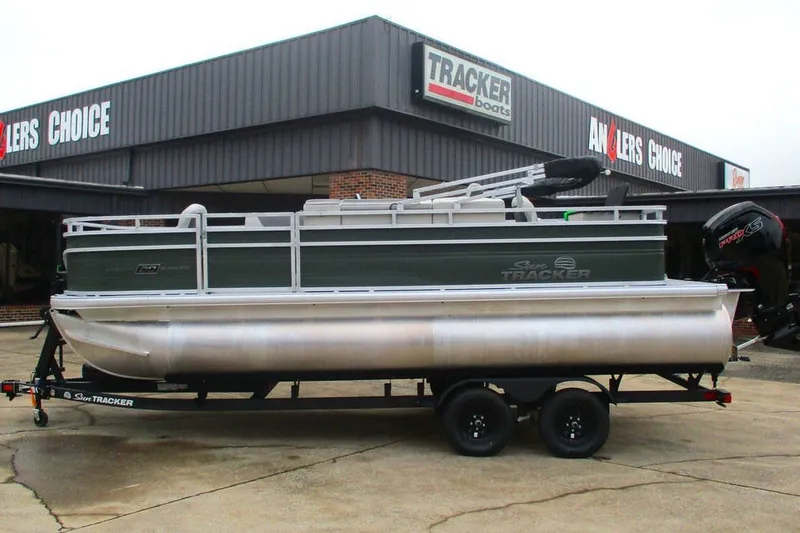 The Image of 2027 Sun Tracker Fishin' Barge 20 DLX pontoon boat on trailer at dealership. - 1