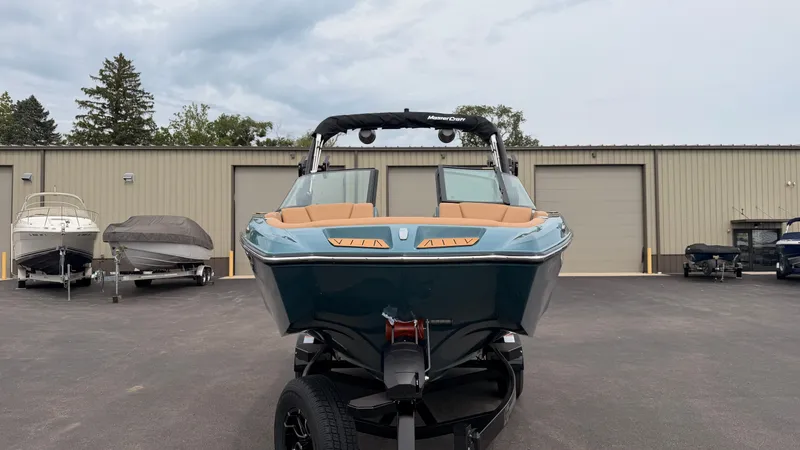 Slide: The Image of A 2027 MasterCraft XT22 on a trailer in front of a warehouse building. - 2