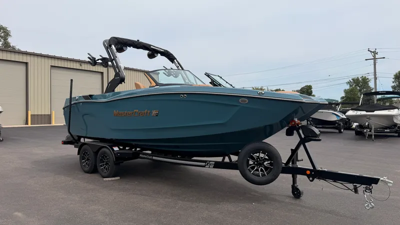 Slide: The Image of A 2027 MasterCraft XT22 boat on a trailer in a parking lot. - 1