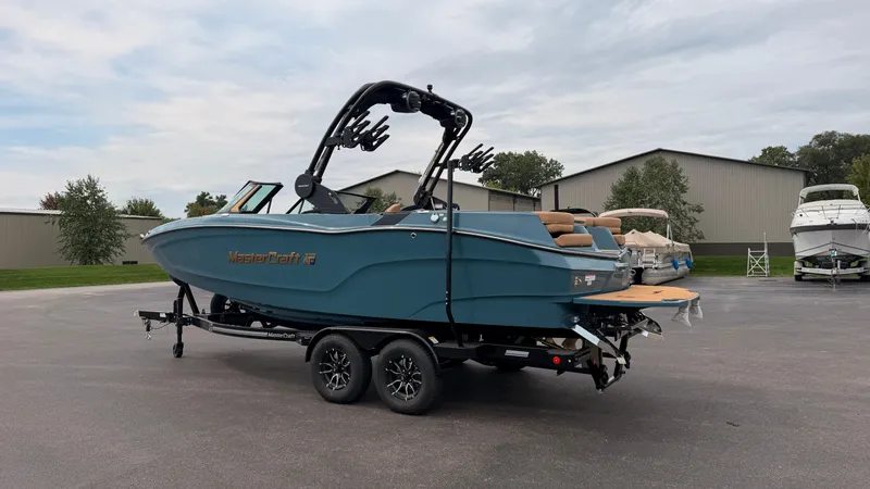 Slide: The Image of A blue MasterCraft XT22 boat from 2027 sits on a trailer in a parking lot. - 4