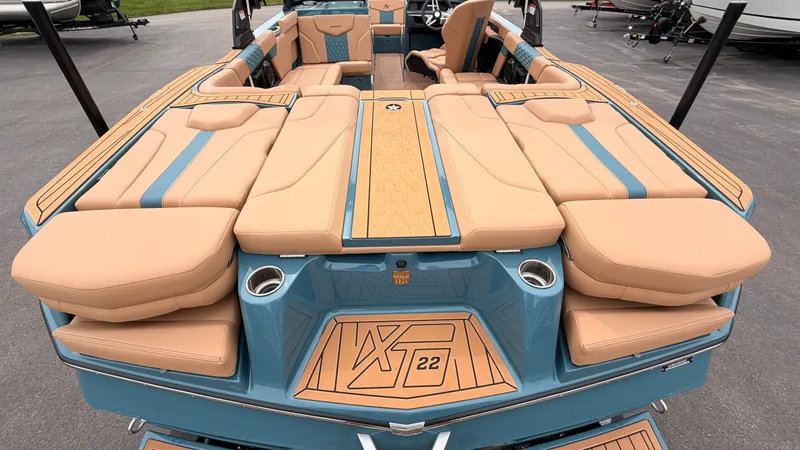 Slide: The Image of The image shows the rear of a 2027 MasterCraft XT22 boat with beige upholstery and blue accents. - 11