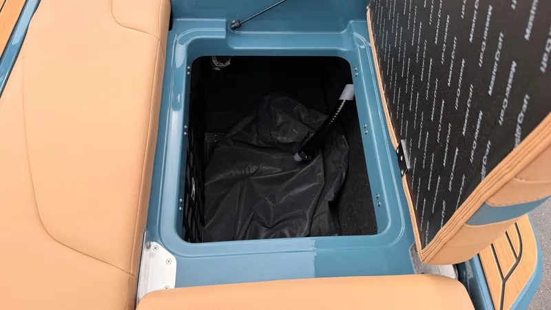 Slide: The Image of An open storage compartment on a boat with blue and beige upholstery. - 18