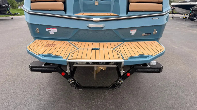 Slide: The Image of The image shows the rear of a blue MasterCraft XT22 boat with a wooden platform. - 9
