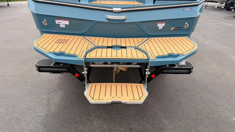 Slide: The Image of The image shows the rear of a 2027 MasterCraft XT22 with a teak swim platform. - 10