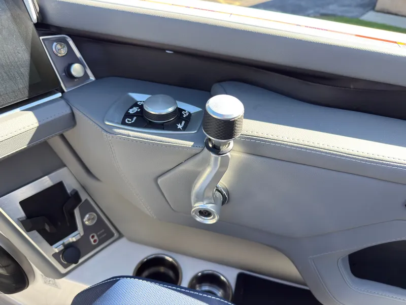 Slide: The Image of Close-up of the control area in a MasterCraft XT22 boat with throttle and controls. - 26