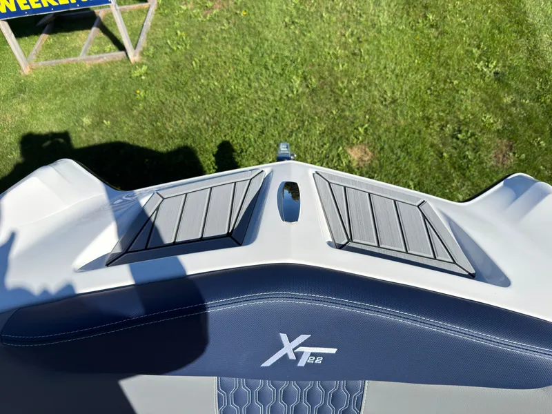 Slide: The Image of The image shows the bow deck of a MasterCraft XT22 boat on a grassy area. - 13