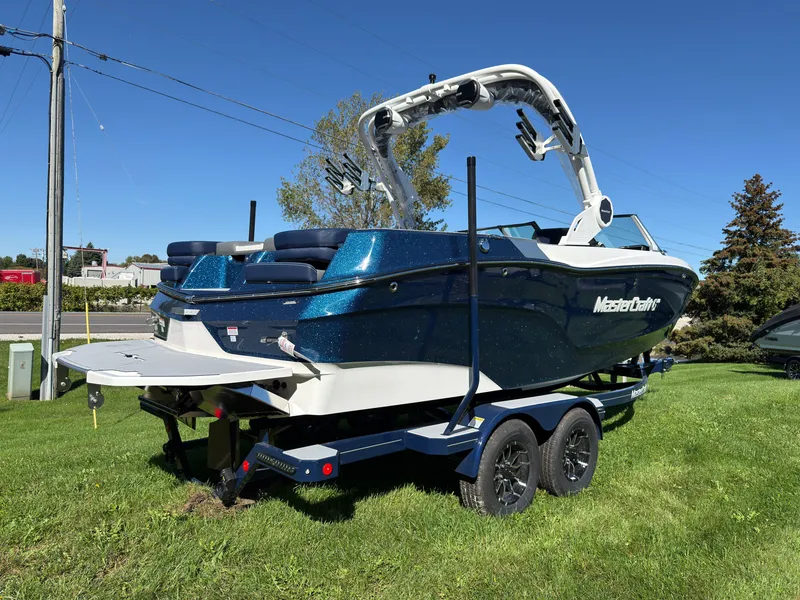 Slide: The Image of A 2027 MasterCraft XT22 on a trailer, parked on a grassy area. - 8