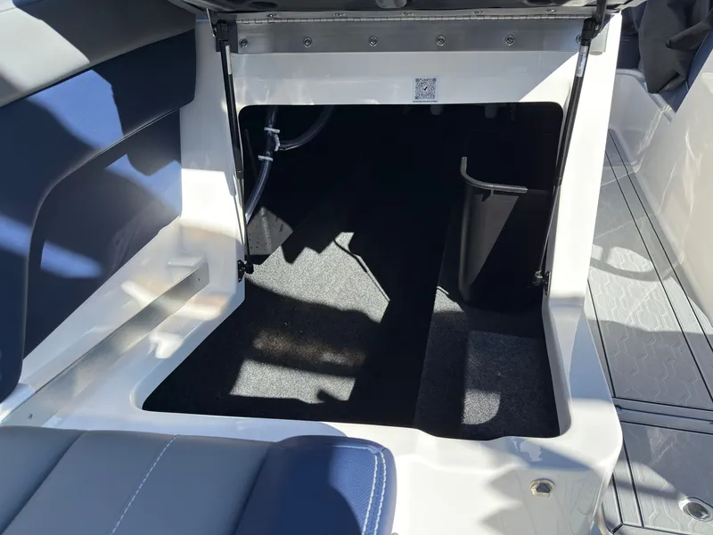 Slide: The Image of An open storage compartment in the boat with carpeted floor and blue upholstery. - 48