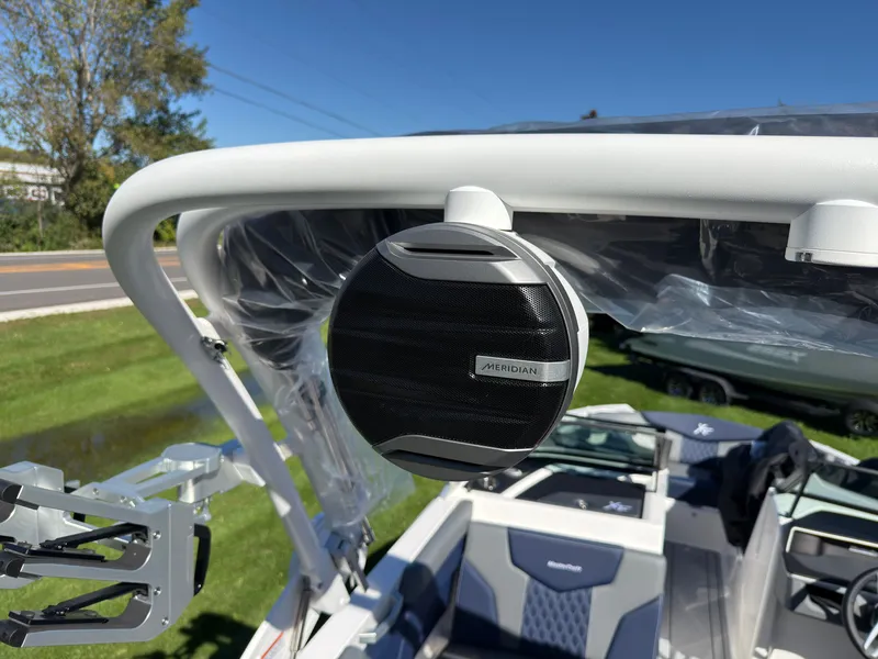Slide: The Image of A speaker is mounted on a white boat arch. Trees and grass are visible in the background. - 43