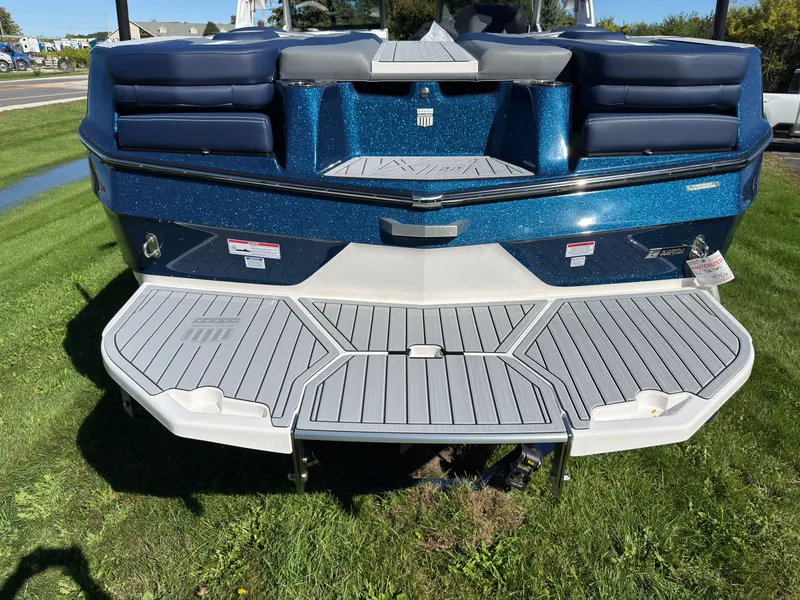 Slide: The Image of The image shows the rear of a blue MasterCraft XT22 boat with a large swim platform. - 10