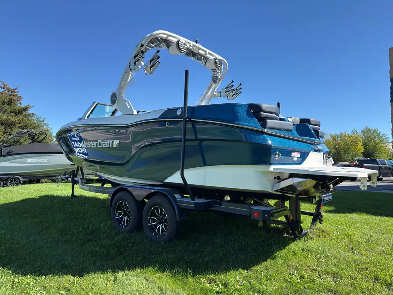 Slide: The Image of A 2027 MasterCraft XT22 boat on a trailer, parked on a grassy area. - 6