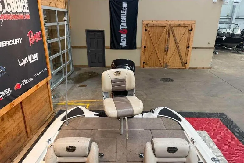 Slide: The Image of 2007 Triton Tr-186 boat interior in showroom with promotional banners and wooden doors. - 3