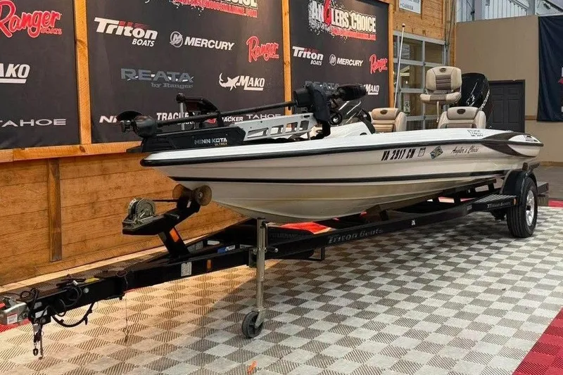Slide: The Image of 2007 Triton Tr-186 boat on trailer in showroom, surrounded by brand logos. - 2