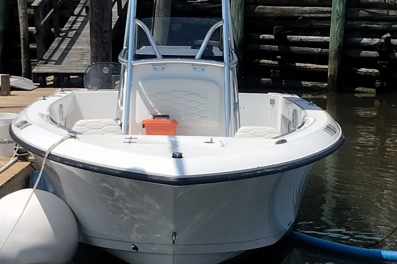 The Image of 2024 Aquasport 2200 Center Console boat docked at a marina. - 0