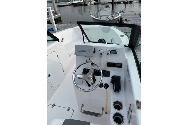 Slide: The Image of 2024 Aquasport 2200 Dual Console boat helm with Garmin navigation system at marina. - 5