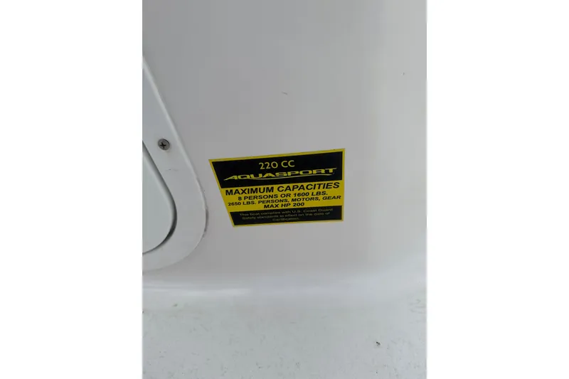 Slide: The Image of 2024 Aquasport 2200 Dual Console capacity label, showing maximum weight and passenger limits. - 8
